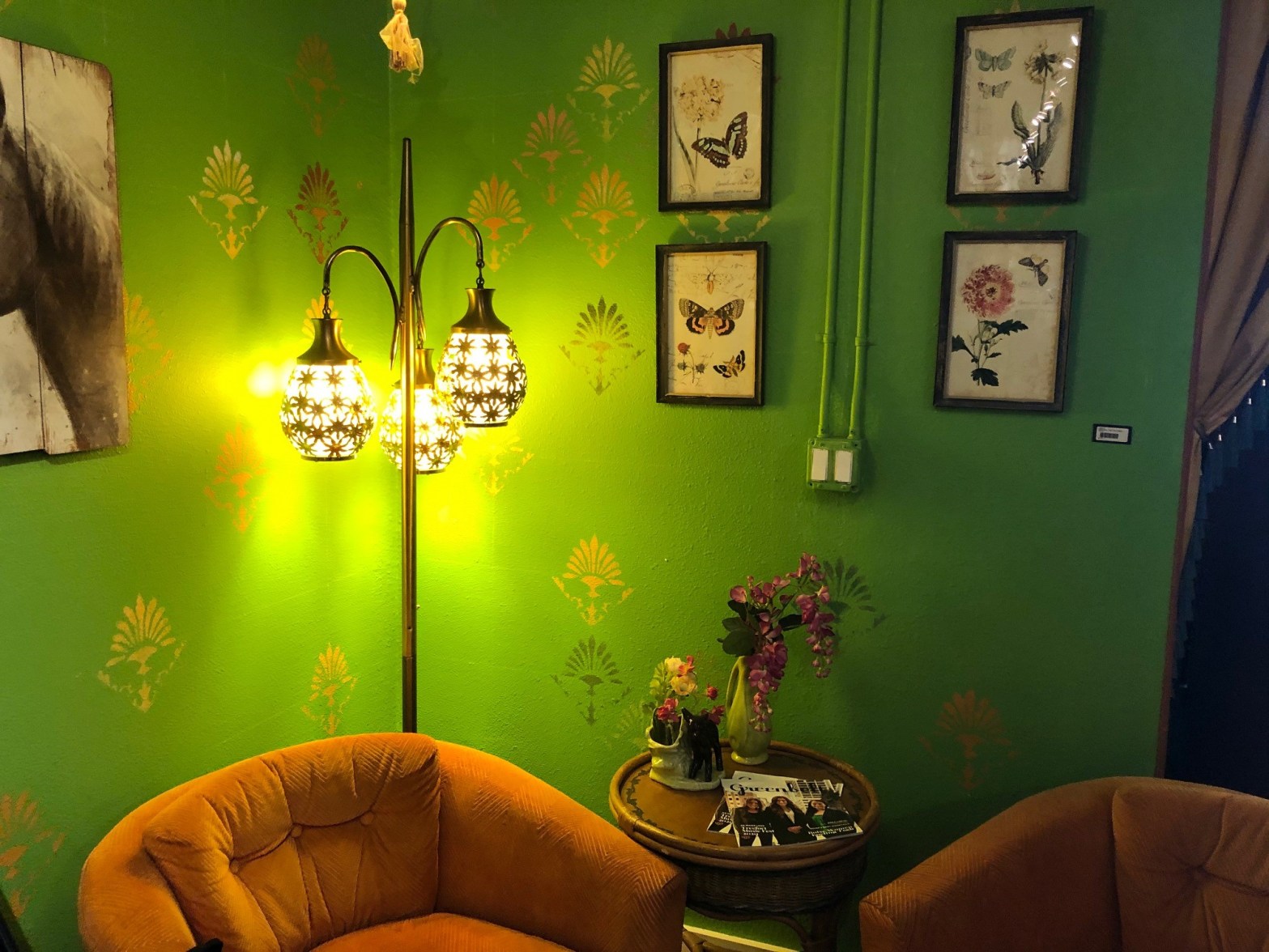 A comfortable corner with a chair and green wall